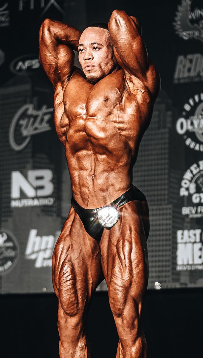 Coach is posing and showing his muscles ina competition